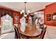 Dining room view showcasing a large table, red walls, decor, and archway views to other rooms at 1019 Wolf Springs Ct, Lawrenceville, GA 30043