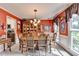 Dining room with red walls, a large wooden table, and a view to the kitchen at 1019 Wolf Springs Ct, Lawrenceville, GA 30043