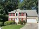 Charming two-story home featuring a well-manicured lawn, bright red shutters, and an attached two-car garage at 1019 Wolf Springs Ct, Lawrenceville, GA 30043