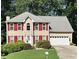 Charming two-story home with red shutters, a well-manicured lawn, and an attached two-car garage at 1019 Wolf Springs Ct, Lawrenceville, GA 30043