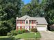 Inviting two-story home with red shutters, lush greenery, and a convenient attached garage at 1019 Wolf Springs Ct, Lawrenceville, GA 30043