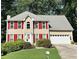 Charming two-story home featuring a well-manicured lawn, bright red shutters, and an attached two-car garage at 1019 Wolf Springs Ct, Lawrenceville, GA 30043