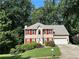 Charming two-story home featuring a well-manicured lawn, bright red shutters, and an attached two-car garage at 1019 Wolf Springs Ct, Lawrenceville, GA 30043