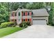 Beautiful two-story home with a lush front lawn, red shutters, and a convenient attached garage at 1019 Wolf Springs Ct, Lawrenceville, GA 30043