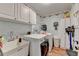 Laundry room featuring utility sink, washer, dryer, and storage cabinets at 1019 Wolf Springs Ct, Lawrenceville, GA 30043