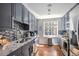 The galley kitchen has gray cabinets, modern appliances, and a sleek tiled backsplash at 195 14Th St # 902, Atlanta, GA 30309