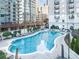 Inviting community swimming pool surrounded by lounge chairs, manicured landscaping, and luxury high rise buildings at 195 14Th St # 902, Atlanta, GA 30309