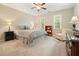 Cozy bedroom featuring neutral tones, plush carpet, and a ceiling fan for added comfort at 3267 Standing Peachtree Trl, Kennesaw, GA 30152