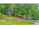 Charming home nestled among mature trees, featuring a well-manicured lawn and inviting curb appeal at 3267 Standing Peachtree Trl, Kennesaw, GA 30152