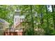 Rear view of home showcasing deck, backyard patio and surrounded by lush trees at 3267 Standing Peachtree Trl, Kennesaw, GA 30152