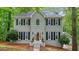 Charming two-story home featuring a gray brick facade, black shutters, and a manicured front yard at 3267 Standing Peachtree Trl, Kennesaw, GA 30152