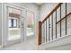 Bright entryway with white tile floors, a staircase with wood and black railings, and a glass door at 5933 Brookside Oak Cir, Norcross, GA 30093