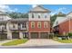 Charming townhome featuring a brick facade and individual garages, set against a backdrop of mature trees at 5933 Brookside Oak Cir, Norcross, GA 30093