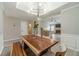 Dining room with a modern light fixture, wood table, and light gray walls at 2895 Dominion Walk Ln, Snellville, GA 30078