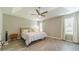 This light-filled main bedroom offers a tray ceiling with fan and neutral colors at 2895 Dominion Walk Ln, Snellville, GA 30078