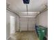 Garage with a roll up door, concrete flooring, utility bins, and side entry door at 366 O Brian Dr, Stone Mountain, GA 30088