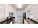 Galley kitchen features stainless steel appliances, dark countertops, white cabinetry and eat in nook at the end at 366 O Brian Dr, Stone Mountain, GA 30088