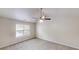 Spacious carpeted bedroom with a ceiling fan and natural light from a large window at 488 Barclay Ct, Stone Mountain, GA 30083