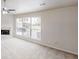 Spacious living room features neutral carpet and a fireplace, with a large window overlooking the front yard at 488 Barclay Ct, Stone Mountain, GA 30083