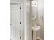 Cozy powder room features a pedestal sink, oval mirror, and modern lighting at 488 Barclay Ct, Stone Mountain, GA 30083