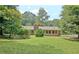 Expansive backyard featuring mature trees and lush lawn with a sunroom addition at 501 Bridlepath Ln, Peachtree City, GA 30269