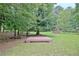 Large backyard with a wooden deck or platform, surrounded by lush greenery at 501 Bridlepath Ln, Peachtree City, GA 30269