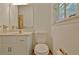 Bathroom featuring a large mirror, toilet, sink, storage cabinet and window for natural light at 501 Bridlepath Ln, Peachtree City, GA 30269