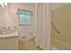 Bathroom with a marble countertop vanity, a window, shower/tub, and handrail at 501 Bridlepath Ln, Peachtree City, GA 30269