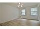 Bright bedroom with wood-look floors, ceiling fan, and natural light from two windows at 501 Bridlepath Ln, Peachtree City, GA 30269