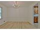 Elegant dining room featuring wainscoting, a chandelier, and hardwood floors at 501 Bridlepath Ln, Peachtree City, GA 30269
