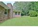 View of house exterior, sunroom, brick chimney, and a well-maintained lawn at 501 Bridlepath Ln, Peachtree City, GA 30269