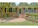 Classic brick home entrance with neatly landscaped shrubs and traditional black shutters at 501 Bridlepath Ln, Peachtree City, GA 30269