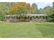 Traditional brick house featuring black shutters and a large front yard shaded by mature trees at 501 Bridlepath Ln, Peachtree City, GA 30269