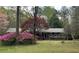 Charming single-story brick home featuring a lush front yard with colorful landscaping and mature trees at 501 Bridlepath Ln, Peachtree City, GA 30269