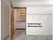Garage with workspace area featuring storage shelves and white base cabinets with a counter at 501 Bridlepath Ln, Peachtree City, GA 30269