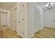 Hallway featuring vinyl floors, neutral walls, updated lighting, and convenient access to multiple rooms at 501 Bridlepath Ln, Peachtree City, GA 30269