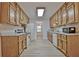 Galley kitchen featuring oak cabinets, modern appliances, and open access to dining area at 501 Bridlepath Ln, Peachtree City, GA 30269