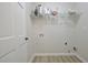 Clean laundry room with wood look vinyl floors, wire shelving, and convenient hookups ready for appliances at 501 Bridlepath Ln, Peachtree City, GA 30269