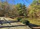 View of the pond with bridge, trees, and blue sky at 501 Bridlepath Ln, Peachtree City, GA 30269