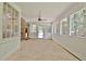 Large sunroom with brick accent wall and windows to the backyard, beadboard ceiling and neutral flooring at 501 Bridlepath Ln, Peachtree City, GA 30269