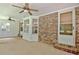 Enclosed sunroom with brick accent wall and a large brick patio area, ceiling fan and large bay window at 501 Bridlepath Ln, Peachtree City, GA 30269