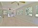 Spacious sunroom boasts beadboard ceiling with dual fans, ample windows with tree views, and neutral flooring at 501 Bridlepath Ln, Peachtree City, GA 30269
