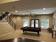 A finished basement featuring a pool table and a stairway, perfect for entertaining and recreation at 605 Meadows Creek Dr, Johns Creek, GA 30005