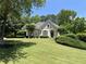 Charming home with manicured front lawn and lush landscaping with mature trees at 605 Meadows Creek Dr, Johns Creek, GA 30005