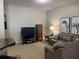 A cozy living area featuring a comfortable sofa, a television, and stylish decor, perfect for relaxation at 605 Meadows Creek Dr, Johns Creek, GA 30005