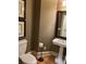Well-appointed powder room with pedestal sink, hardwood floors, and classic mirror at 605 Meadows Creek Dr, Johns Creek, GA 30005