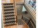 A staircase with hardwood treads, decorative carpet, and iron railings, connecting the home's different levels at 605 Meadows Creek Dr, Johns Creek, GA 30005