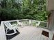 Outdoor deck with white rocking chairs and a view of a lush, green backyard at 6174 S. Skyline Dr, Douglasville, GA 30135
