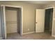 Bedroom with open closet, neutral paint, and white trim throughout at 1701 Charmeth Rd, Lithonia, GA 30058