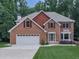 Traditional two-story brick home with a well-manicured lawn, mature trees and an attached two-car garage at 4271 Edgewater Drive Northwest Nw Dr, Kennesaw, GA 30144
